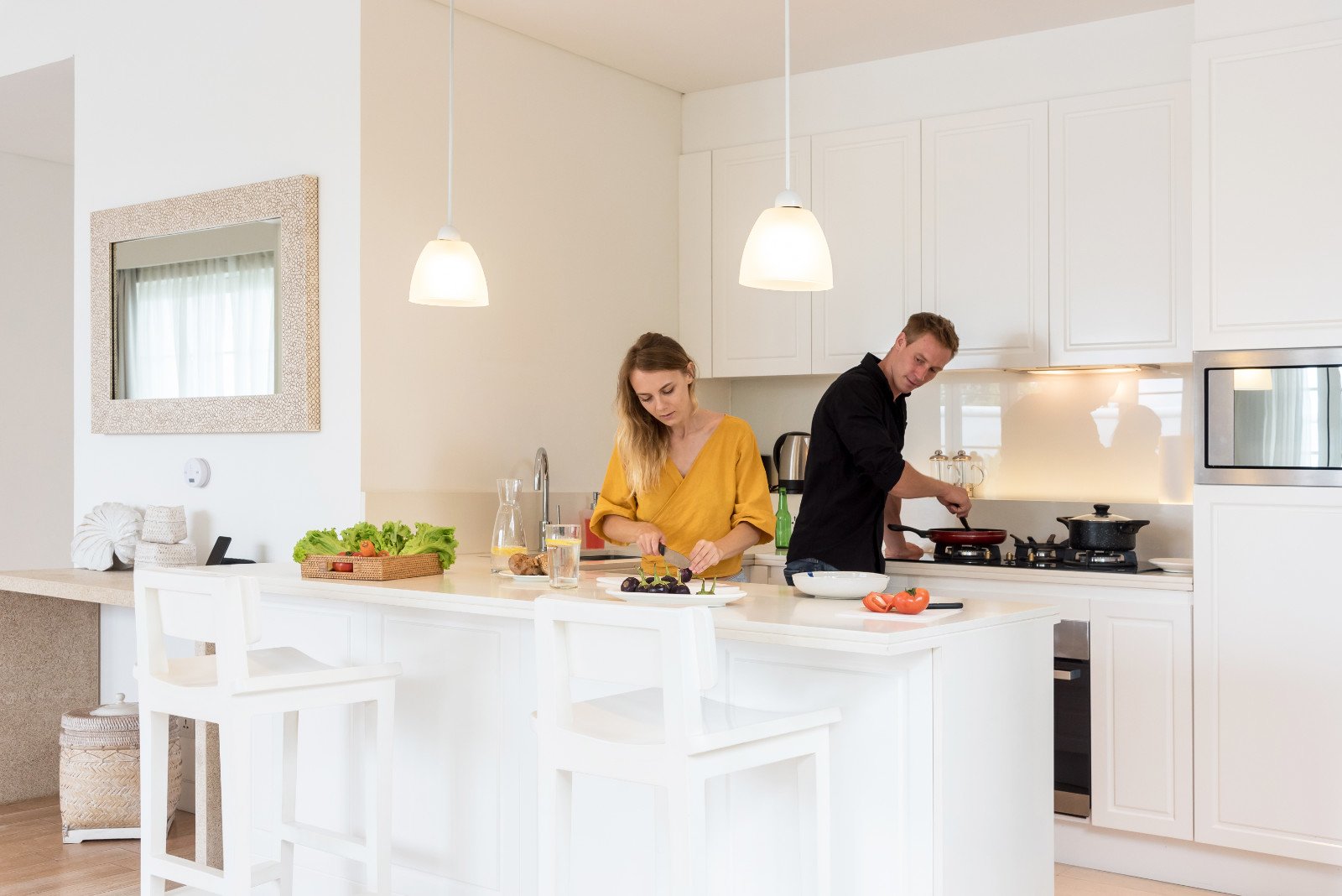 Couple cooking on a white kitchen at home